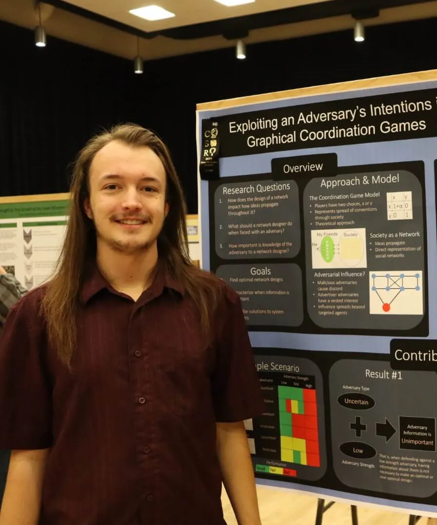 brandon collins standing in front of his 2019 Mountain Lion Research Day poster board